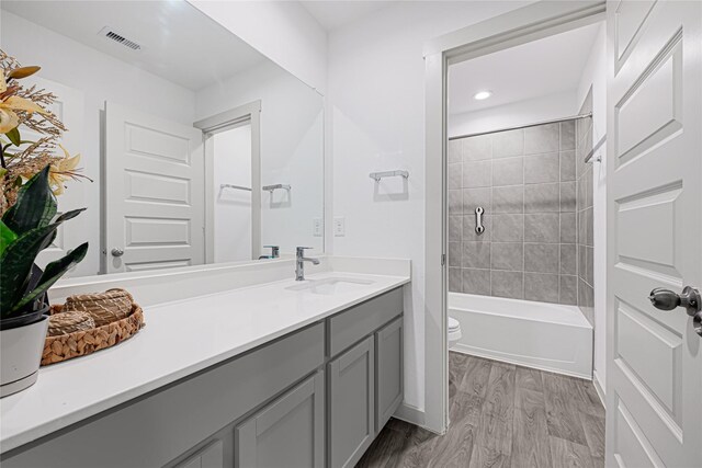 bathroom featuring vanity, toilet, recessed lighting, wood finished floors, and visible vents
