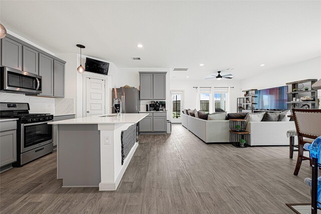 kitchen with dark wood-style flooring, ceiling fan, appliances with stainless steel finishes, light countertops, and gray cabinets