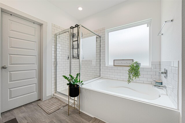 full bath with recessed lighting, a shower stall, wood finished floors, and a garden tub