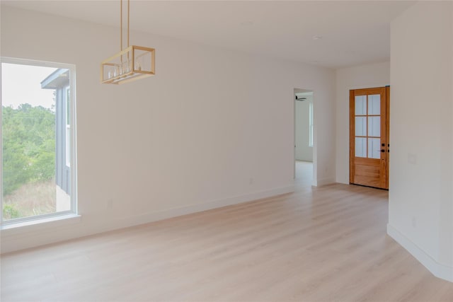 100 Mahalo Ct, Bastrop, TX 78602 - unfurnished room with plenty of natural light, light wood-type flooring, baseboards, and a chandelier