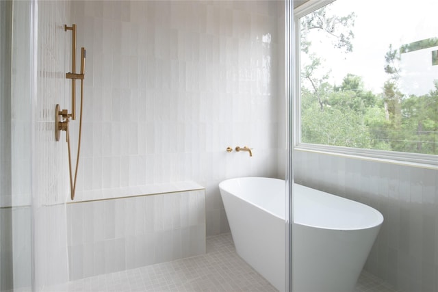 100 Mahalo Ct, Bastrop, TX 78602 - bathroom with tile walls, a soaking tub, and a tile shower
