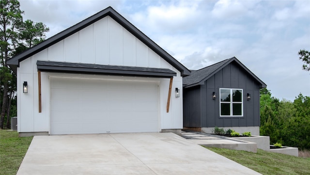 100 Mahalo Ct, Bastrop, TX 78602 - modern inspired farmhouse featuring board and batten siding, driveway, cooling unit, an attached garage, and roof with shingles