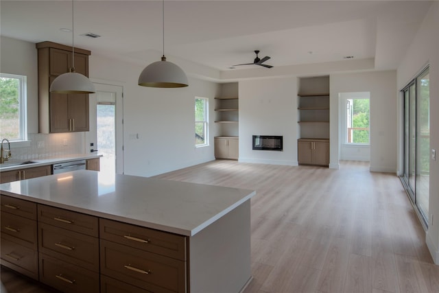 100 Mahalo Ct, Bastrop, TX 78602 - kitchen featuring a sink, light wood finished floors, and a raised ceiling