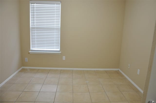 unfurnished room with light tile patterned floors and baseboards