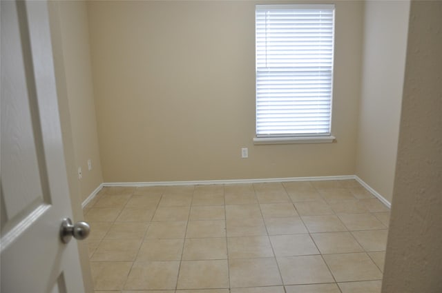 unfurnished room featuring light tile patterned floors and baseboards