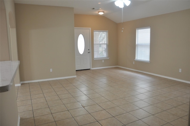 entrance foyer with light tile patterned floors, a ceiling fan, visible vents, vaulted ceiling, and baseboards