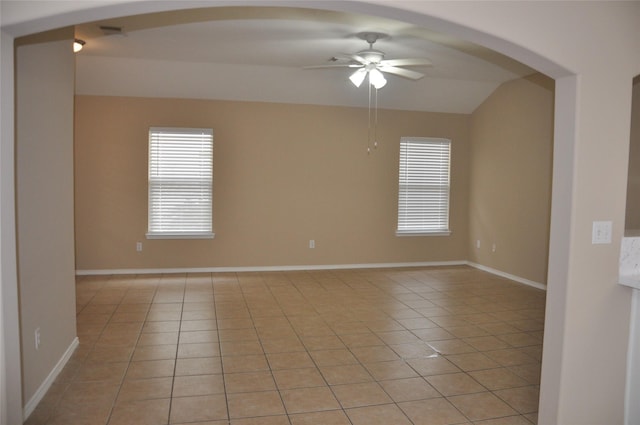 unfurnished room with light tile patterned floors, a ceiling fan, arched walkways, and lofted ceiling