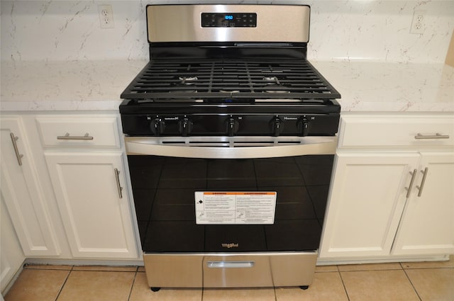 details featuring white cabinetry, gas range, and backsplash