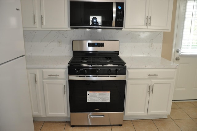 kitchen with white cabinetry, light stone countertops, light tile patterned flooring, and appliances with stainless steel finishes