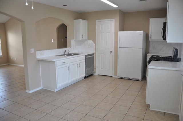 kitchen featuring tasteful backsplash, freestanding refrigerator, dishwasher, a sink, and light tile patterned flooring