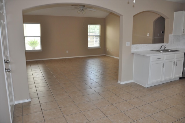kitchen with light tile patterned floors, a healthy amount of sunlight, a ceiling fan, and light countertops