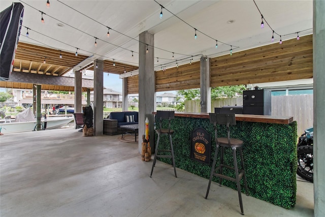 view of patio / terrace featuring fence and outdoor dry bar