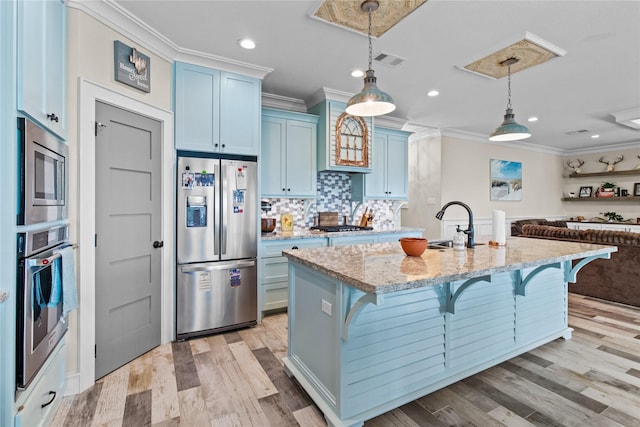 kitchen featuring a breakfast bar area, blue cabinets, appliances with stainless steel finishes, and crown molding