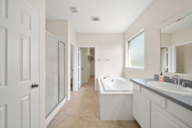 full bathroom featuring visible vents, a shower stall, a bath, and vanity