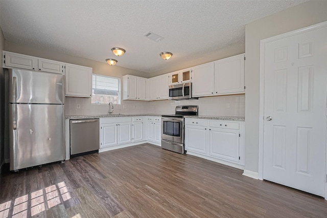 23931 Griffin House Ln, Katy, TX 77493 - kitchen featuring white cabinetry, visible vents, appliances with stainless steel finishes, and dark wood-type flooring