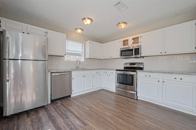 23931 Griffin House Ln, Katy, TX 77493 - kitchen with a sink, white cabinetry, stainless steel appliances, and dark wood-style flooring
