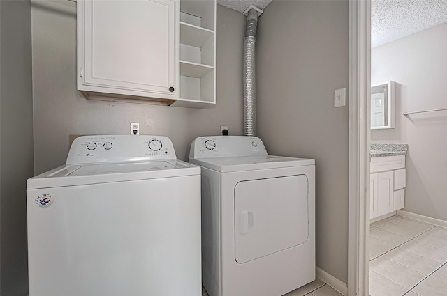 23931 Griffin House Ln, Katy, TX 77493 - clothes washing area with cabinet space, washer and clothes dryer, light tile patterned floors, baseboards, and a textured ceiling