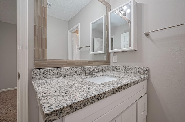 23931 Griffin House Ln, Katy, TX 77493 - bathroom featuring visible vents, a textured ceiling, and vanity