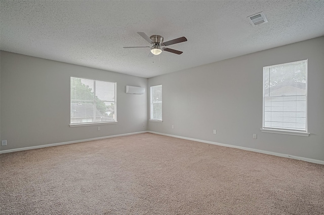 23931 Griffin House Ln, Katy, TX 77493 - spare room with a textured ceiling, a wall unit AC, visible vents, ceiling fan, and carpet