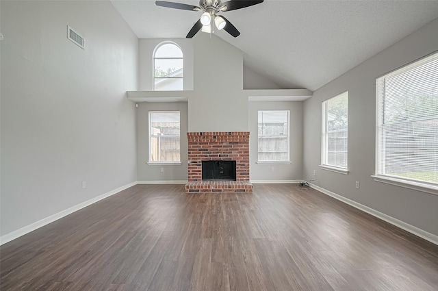 23931 Griffin House Ln, Katy, TX 77493 - unfurnished living room featuring dark wood-style flooring, visible vents, plenty of natural light, and vaulted ceiling