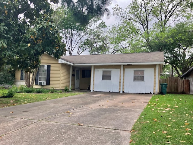 single story home with concrete driveway, fence, a front yard, and cooling unit
