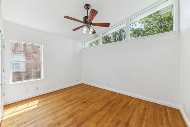 spare room with ceiling fan, plenty of natural light, and light wood-style floors