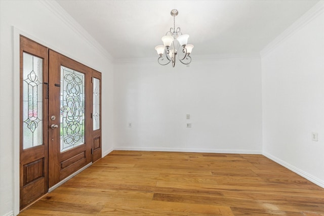 entrance foyer with an inviting chandelier, baseboards, crown molding, and light wood-style flooring