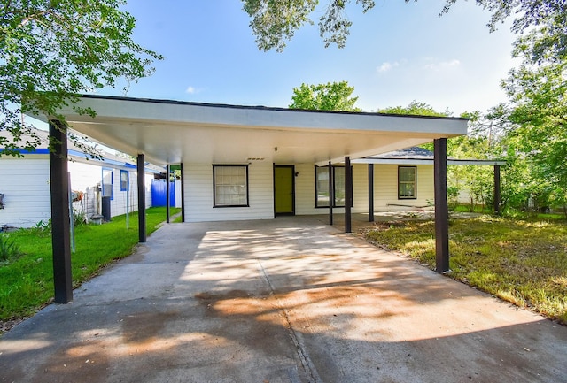 view of front of house with concrete driveway, a front yard, and an attached carport
