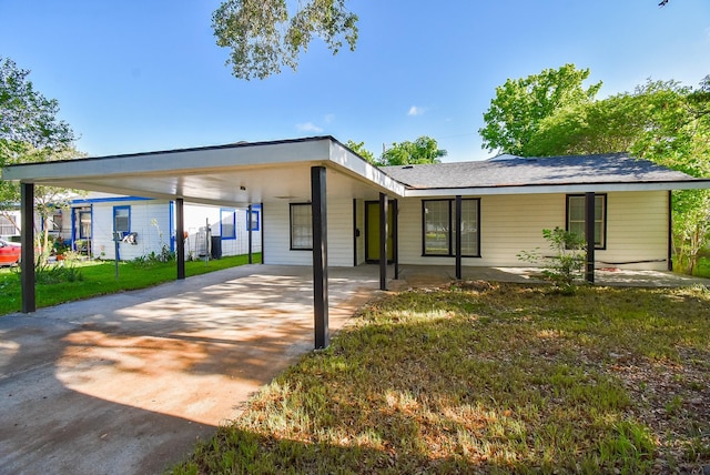 view of front facade with a front lawn, concrete driveway, and an attached carport