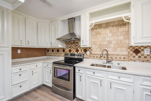 kitchen featuring wall chimney range hood, a sink, white cabinetry, visible vents, and stainless steel electric stove