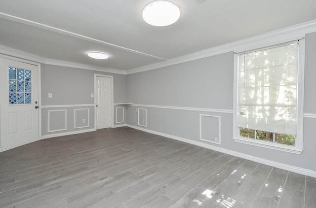 empty room featuring wood finished floors and crown molding