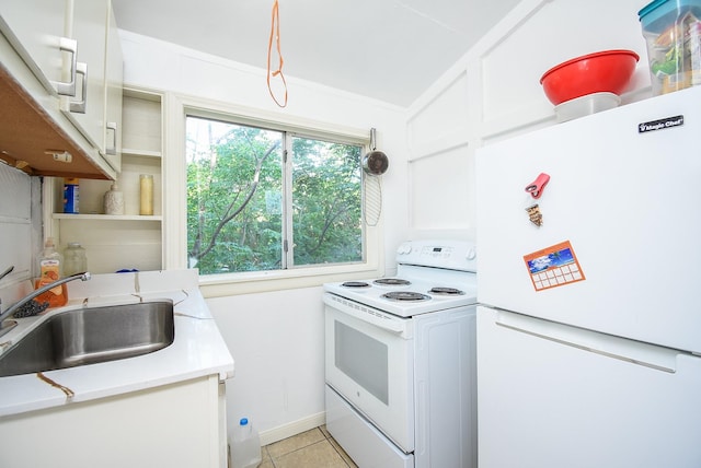kitchen featuring a sink, light tile patterned floors, white appliances, white cabinetry, and light countertops