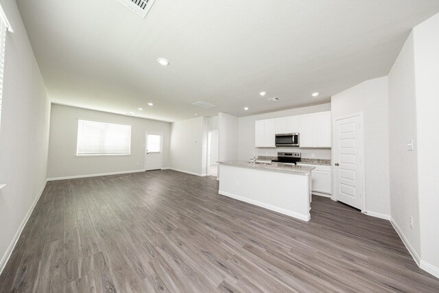 8113 Burnt Orchid Dr, Houston, TX 77016 - kitchen featuring stainless steel appliances, dark wood-style flooring, white cabinets, recessed lighting, and open floor plan