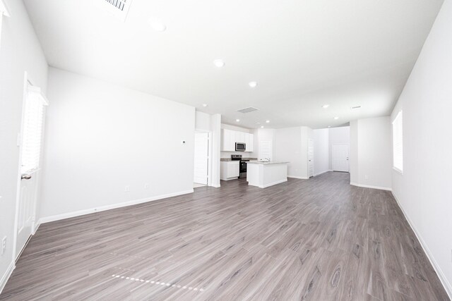 8113 Burnt Orchid Dr, Houston, TX 77016 - unfurnished living room featuring light wood-type flooring and recessed lighting