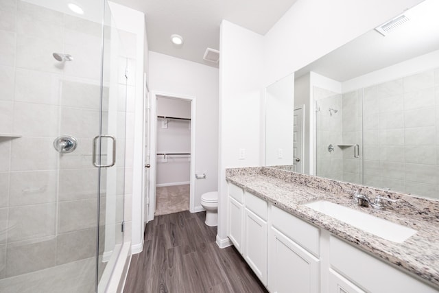 8113 Burnt Orchid Dr, Houston, TX 77016 - bathroom featuring a stall shower, vanity, wood finished floors, and a spacious closet
