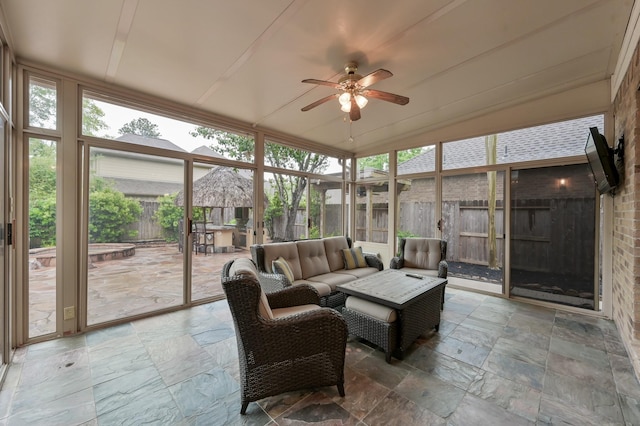 2218 Dawn Wind Ln, Spring, TX 77386 - sunroom featuring stone tile floors, an outdoor hangout area, a ceiling fan, and expansive windows
