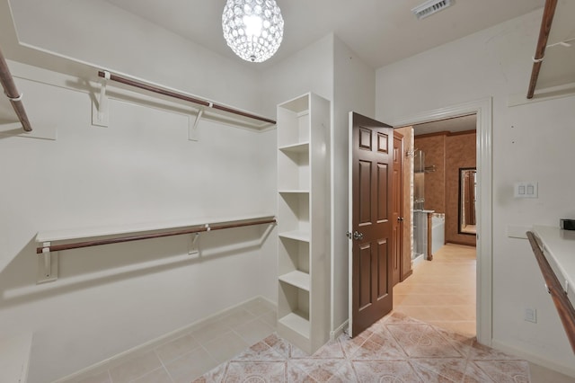 2218 Dawn Wind Ln, Spring, TX 77386 - walk in closet featuring light tile patterned flooring and a chandelier