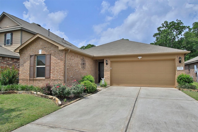 ranch-style home featuring a front lawn, brick siding, a shingled roof, an attached garage, and driveway