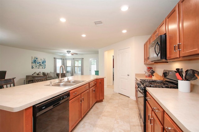 kitchen with brown cabinets, a sink, light countertops, visible vents, and black appliances