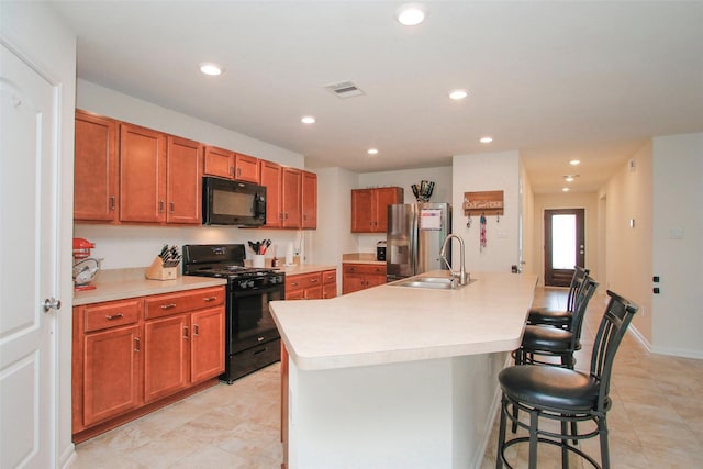 kitchen featuring visible vents, a sink, black appliances, and light countertops