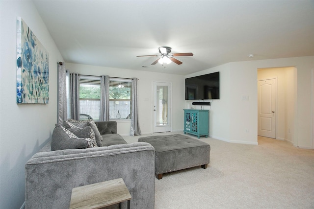 living area with ceiling fan, light colored carpet, and baseboards