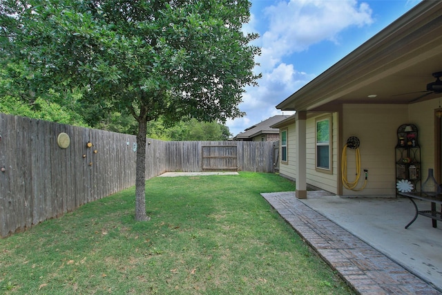 view of yard with a fenced backyard, ceiling fan, and a patio area