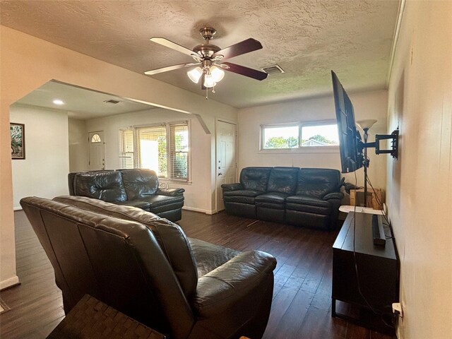 living room with a textured ceiling, ceiling fan, hardwood / wood-style flooring, and visible vents
