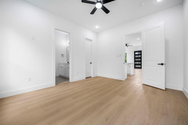unfurnished bedroom with recessed lighting, connected bathroom, light wood finished floors, a sink, and baseboards