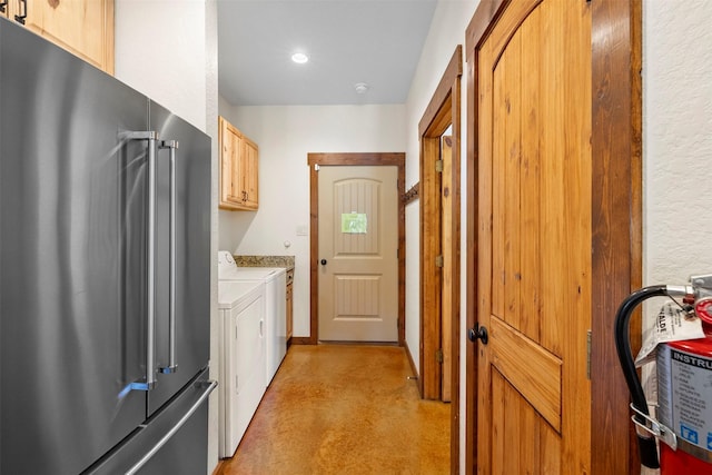 clothes washing area with separate washer and dryer and cabinet space