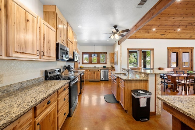 kitchen featuring light stone countertops, visible vents, stainless steel appliances, and a ceiling fan