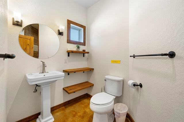 half bath with baseboards and toilet