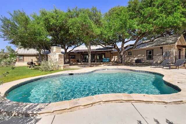pool featuring a patio and a lawn