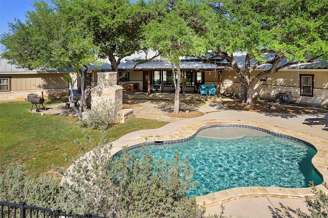 pool with fence, a patio area, and a lawn