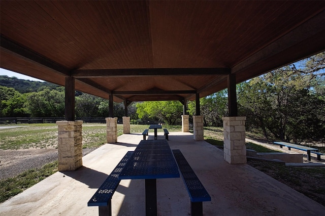 view of home's community featuring fence, a wooded view, and a patio area